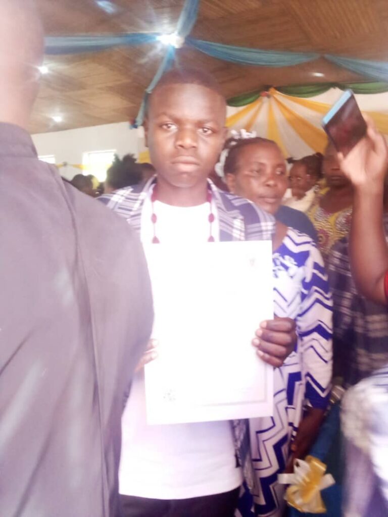 Innocent Denga hält sein Zeugnis in der Hand